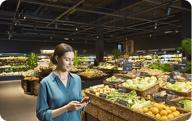 Food and grocery shopper in a market using a phone